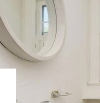 Bathroom Restoration — round wall mirror and faucet